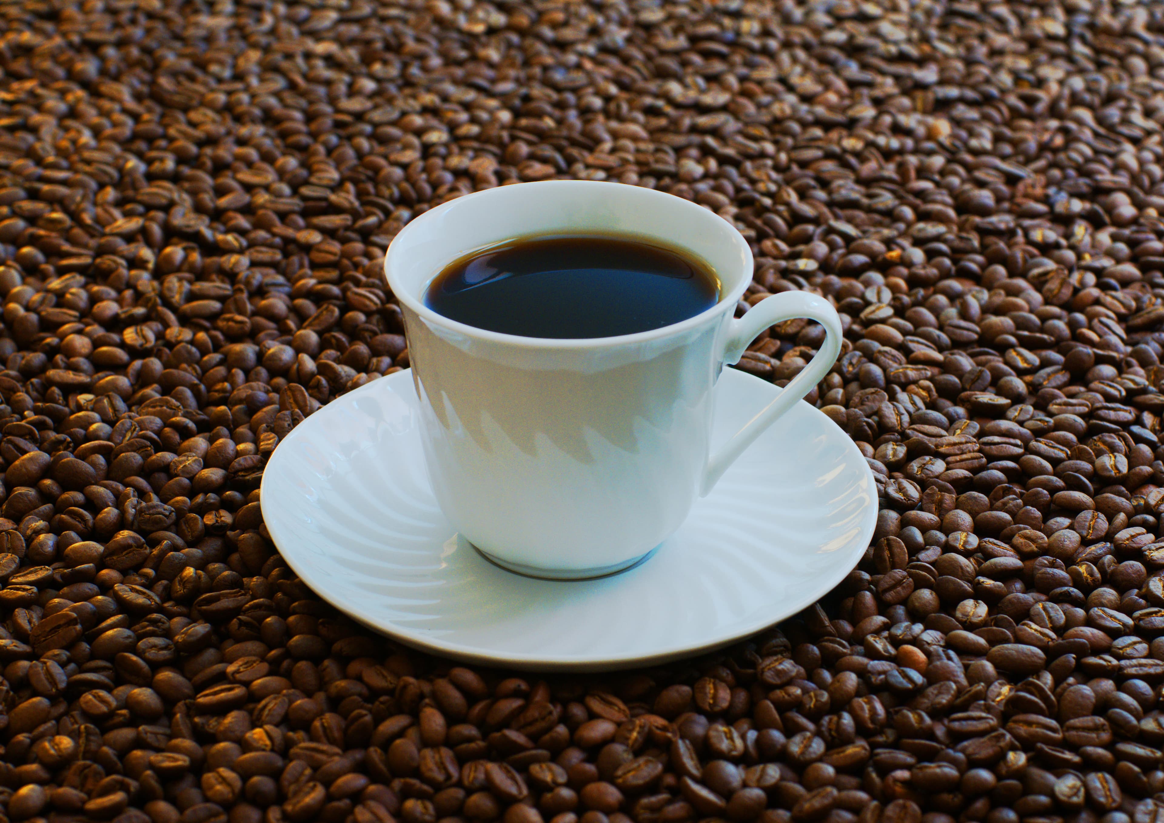 Cup of coffee surrounded by beans