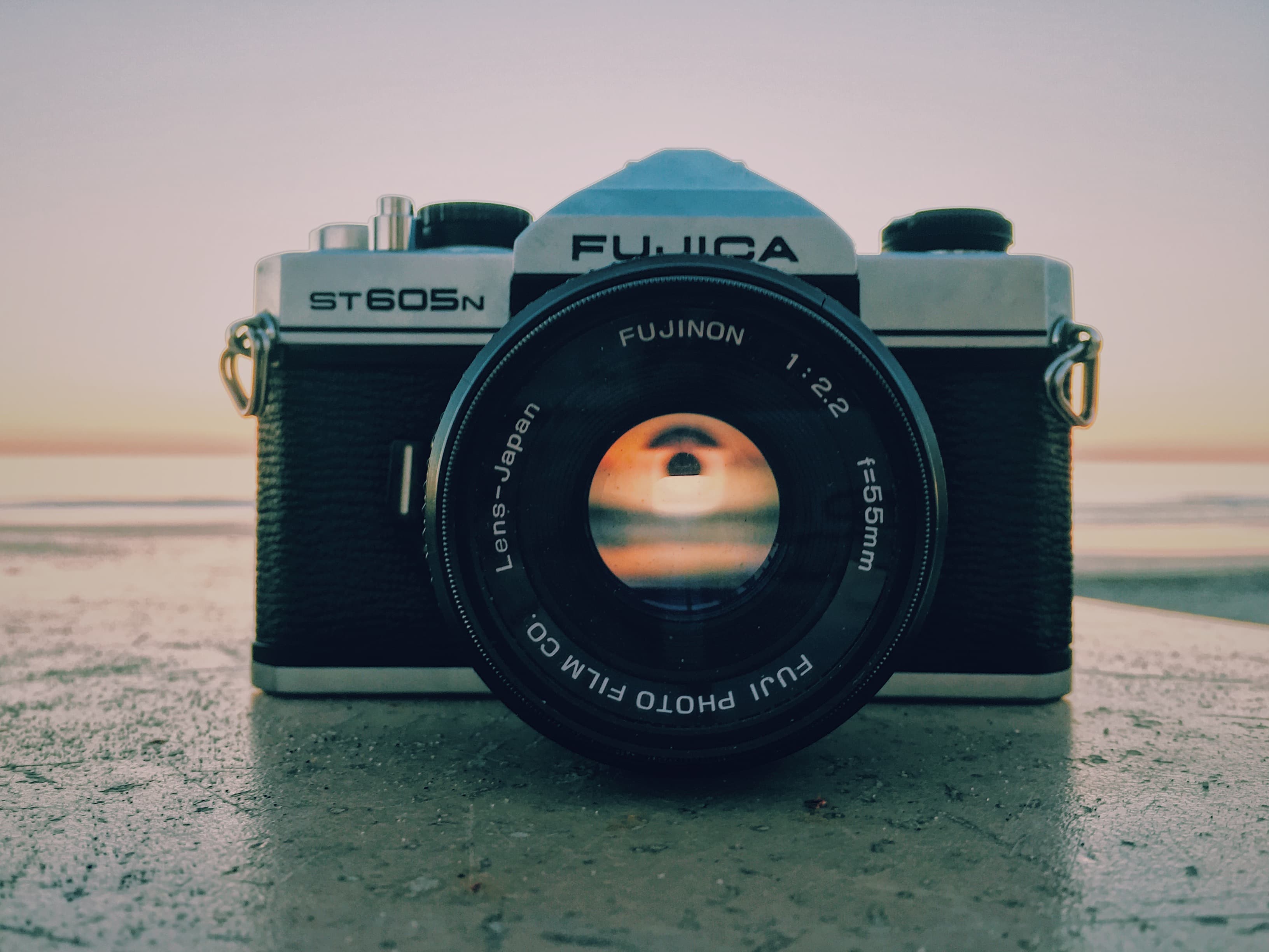 Fujica camera on stone surface (Unsplash)