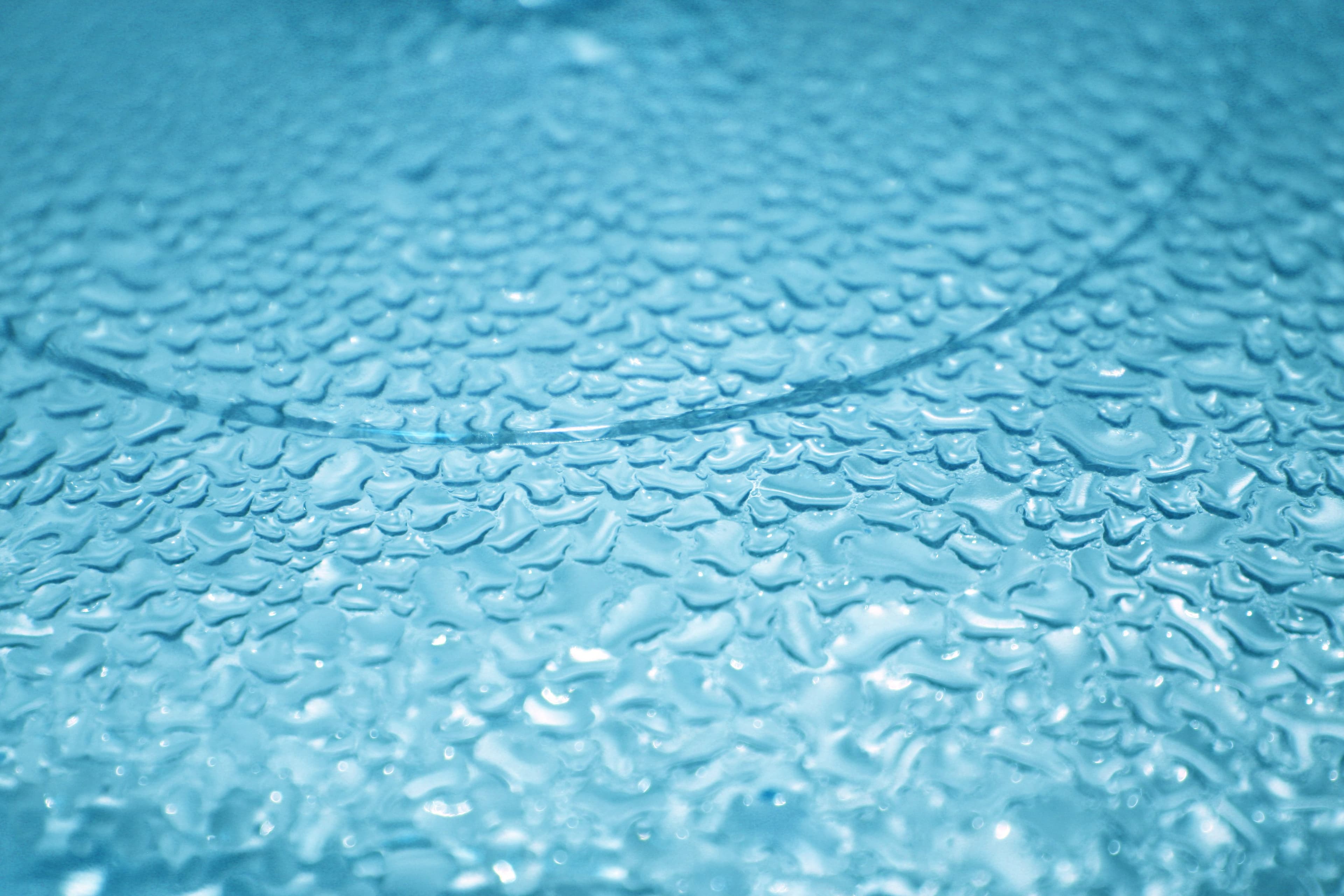 Water droplets on blue glass surface