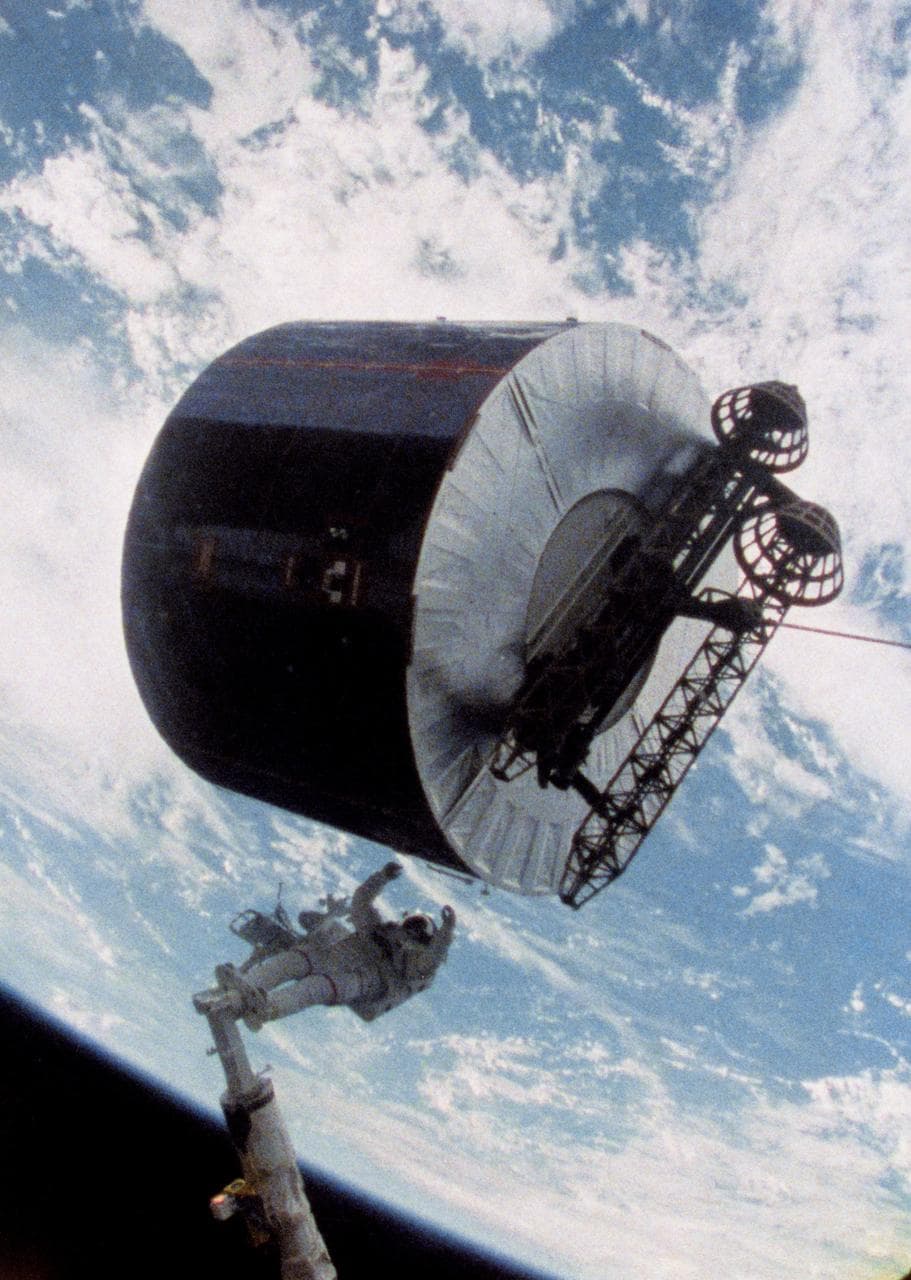 Astronaut James van Hoften working with Syncom IV-3 satellite