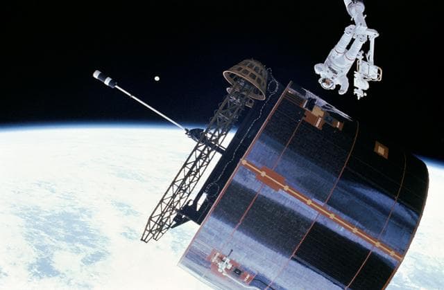 Astronaut James van Hoften working with Syncom IV-3 satellite