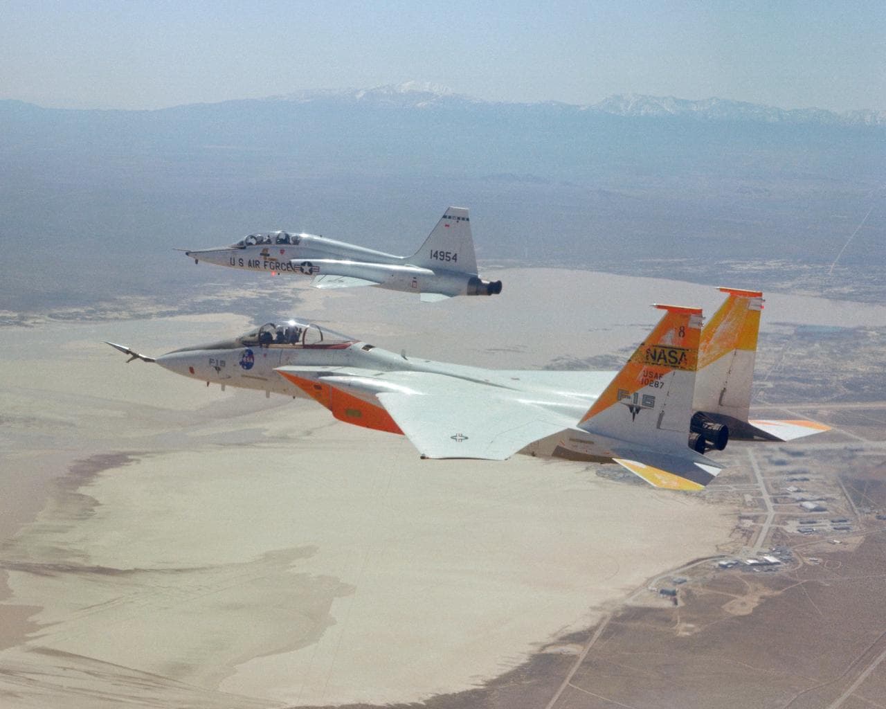 F-15A #287 flies formation with a T-38 chase over Edwards AFB.