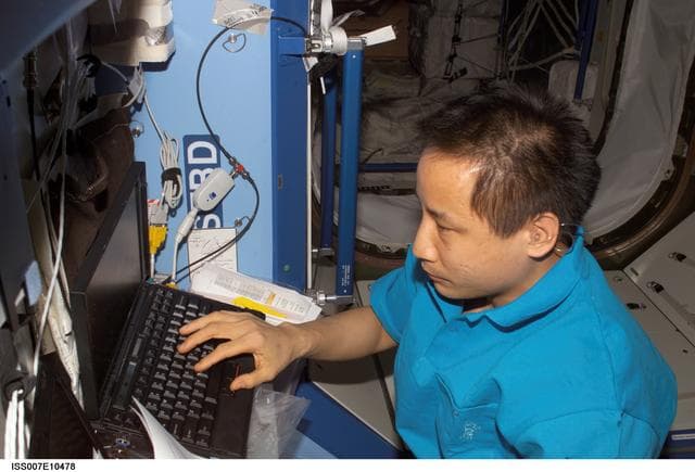 Expedition Seven Science Officer Lu with laptop