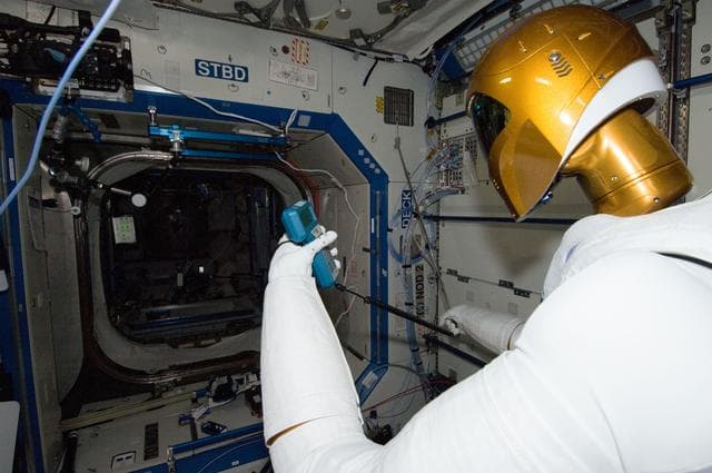 Robonaut 2 Humanoid Robot holds instrument to measure air velocity
