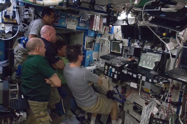 Crewmembers watch Dragon Launch on Computer Screen