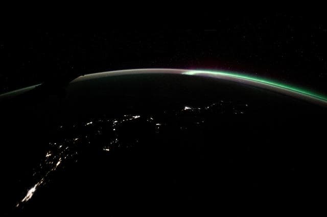 The aurora australis blends with Earth's atmospheric glow