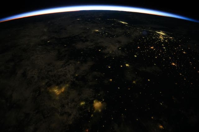 An orbital sunrise crowns Earth's horizon
