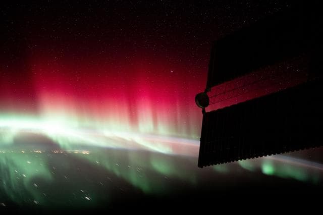 A red and green aurora shimmers brightly above Ontario, Canada