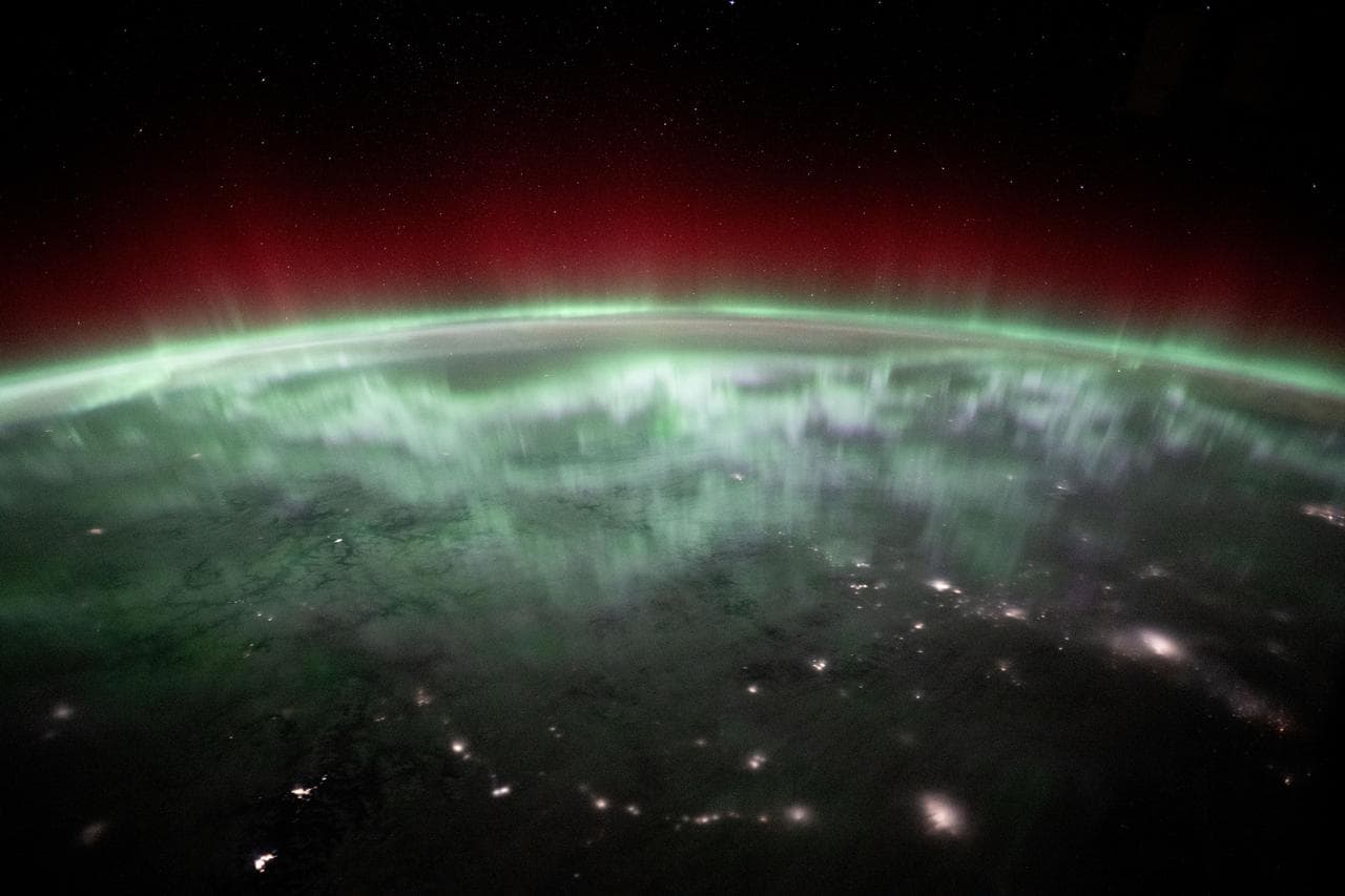An aurora shimmers and dances above the city lights of Canada