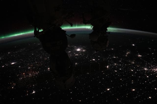 The aurora borealis crowns Earth's horizon above Canada
