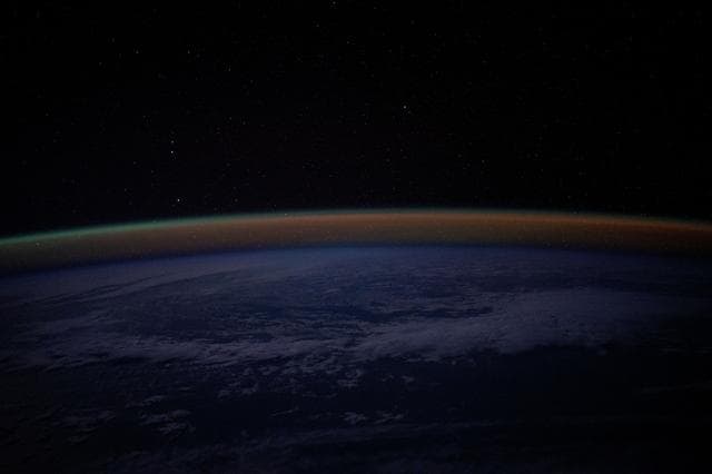 An atmospheric glow blankets Earth's horizon