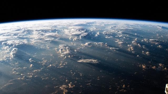 A Southeast Asian sunrise casts long shadows behind clouds