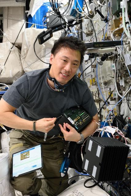 NASA astronaut Jonny Kim works on computer networking maintenance