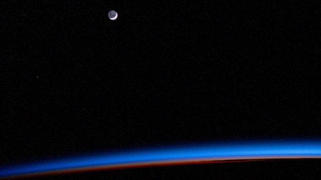 The waning crescent Moon above Earth's horizon