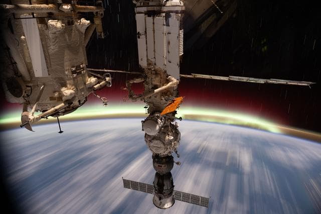 The aurora australis streams above Earth's horizon
