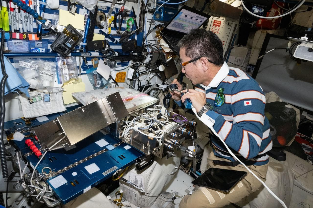 JAXA astronaut Kimiya Yui works on computer networking hardware