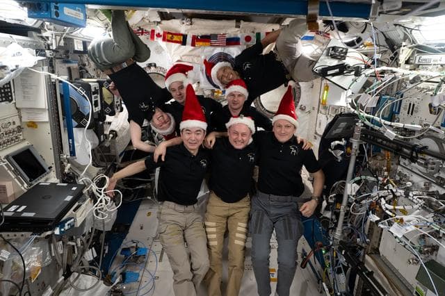 The seven-member Expedition 74 crew poses for a festive portrait
