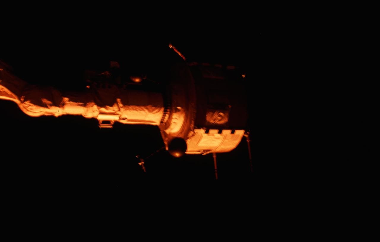 PDP grappled by RMS is positioned above payload bay (PLB) at sunrise