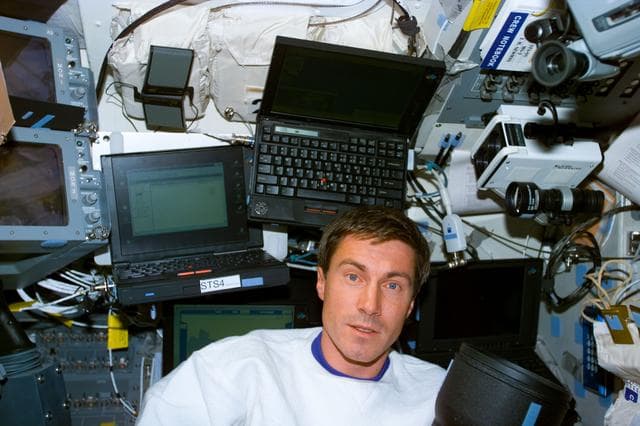 Krikalev on the aft flight deck with laptop computers