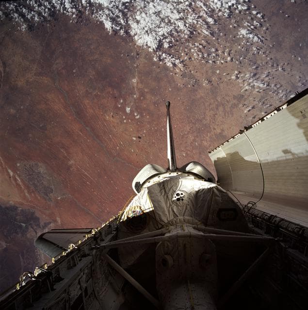 Payload bay with Spacelab backdropped by Earth