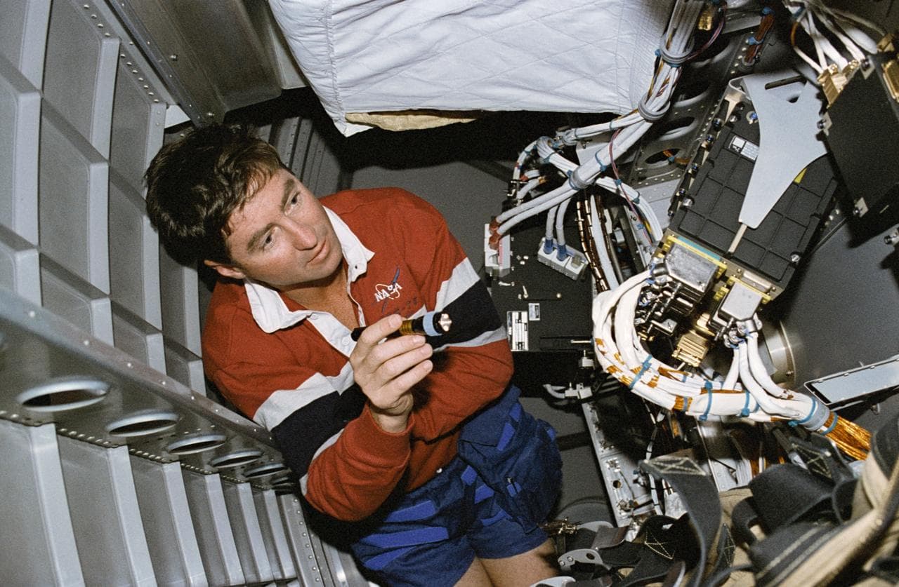 Henricks examines the computer systems under the Spacelab floor