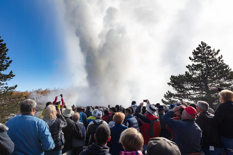 People watch and photograph a Steamboat Geyser eruption