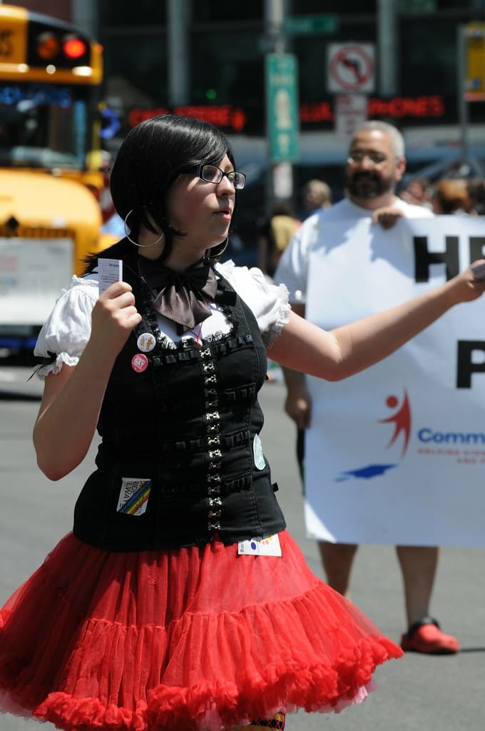 Girl in red dress handing out pamphlets at Gay Pride Parade
