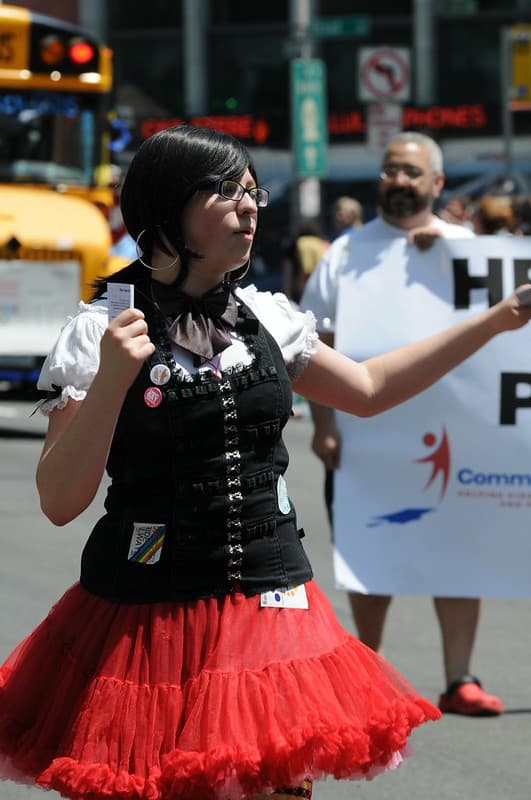 Girl in red dress handing out pamphlets at Gay Pride Parade