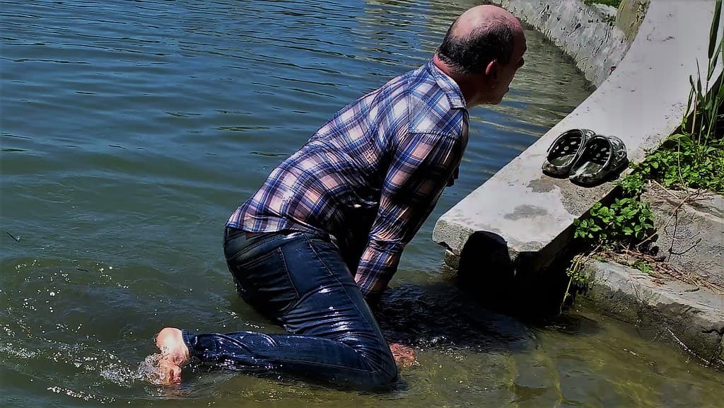 Wet guy climbs out of the water