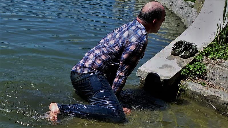 Wet guy climbs out of the water