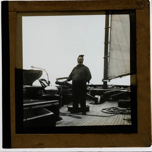 Skipper on board a boat, possibly a ketch, lugger or yawl, early 1900s