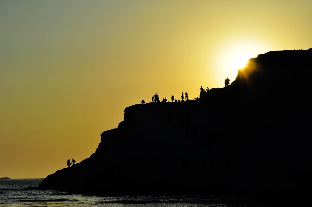 Divers on Ocean Cliff at Sunset