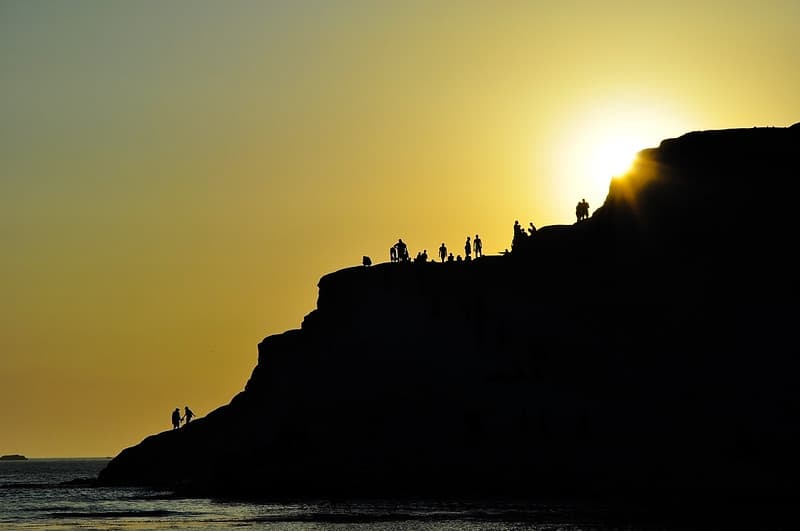 Divers on Ocean Cliff at Sunset