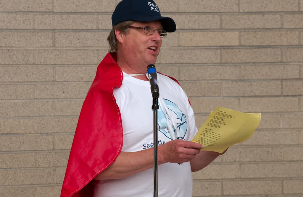 Man in red cape leading singing workshop 2