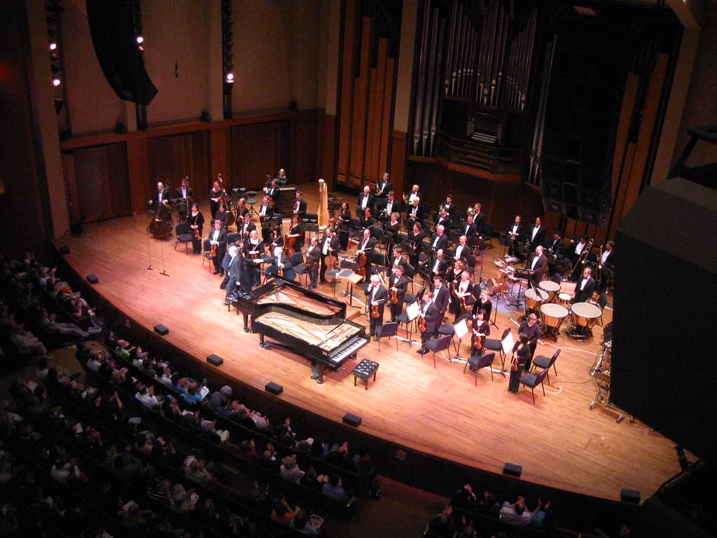 Kevin Cole shaking hands with lead violinist