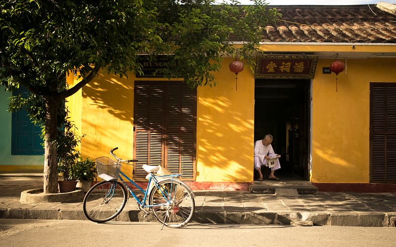 Asian Home with Man Reading Paper and Bicycle