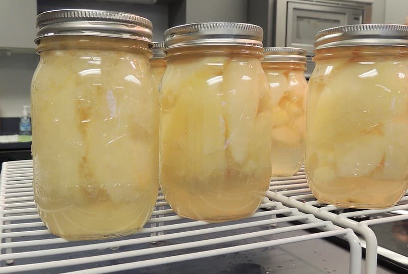 Finished canned pears in jars on a wire rack