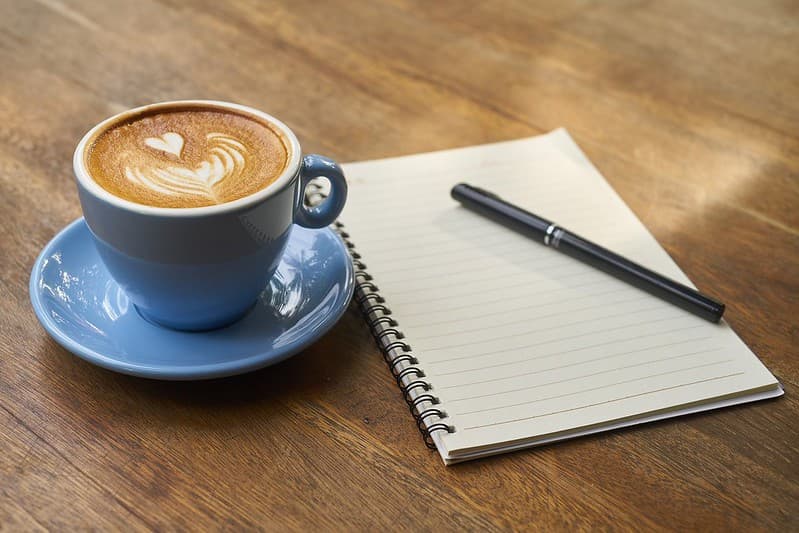 Coffee with Notebook on table in office