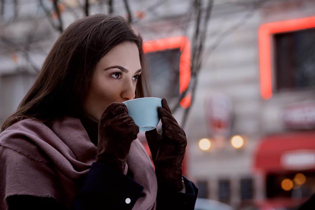 A woman drinking coffee outdoors