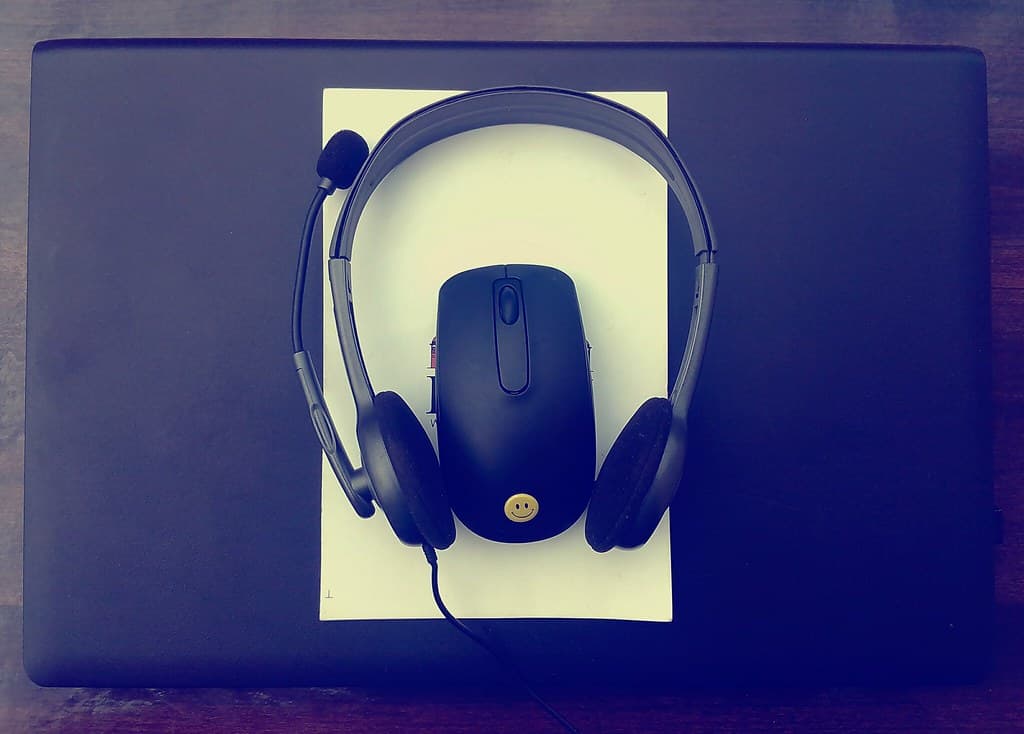 Dark black mouse and headphone on laptop