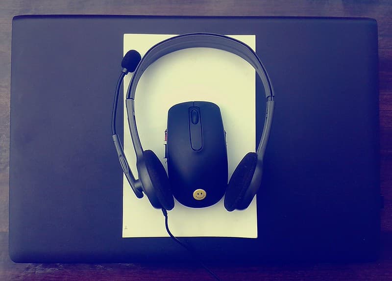 Dark black mouse and headphone on laptop
