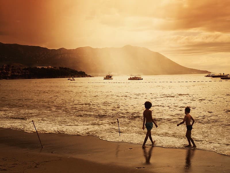 Children on Beach with Boats in Water