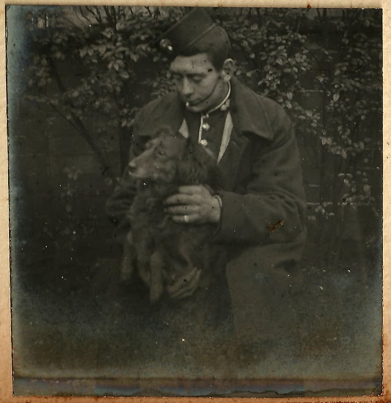 Young man, possibly in bandsman uniform, with his dog, early 1900s