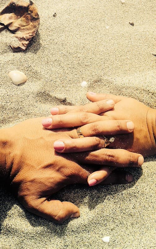 Married Couple Holding Hands on Sandy Beach