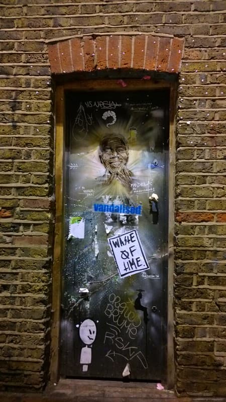 Nelson Mandela graffiti on door to nowhere in Brick Lane in London