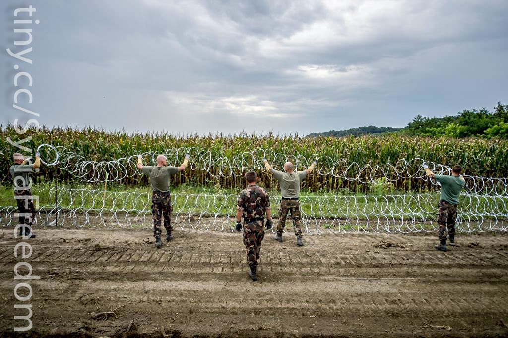 Hungarian soldiers install a wire fence