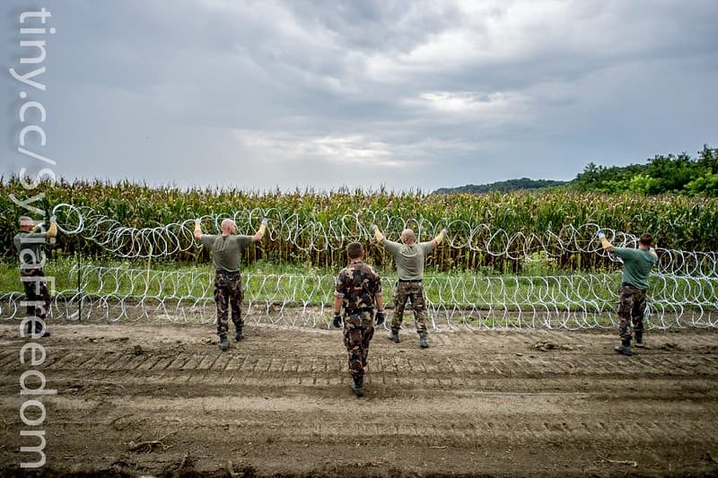Hungarian soldiers install a wire fence