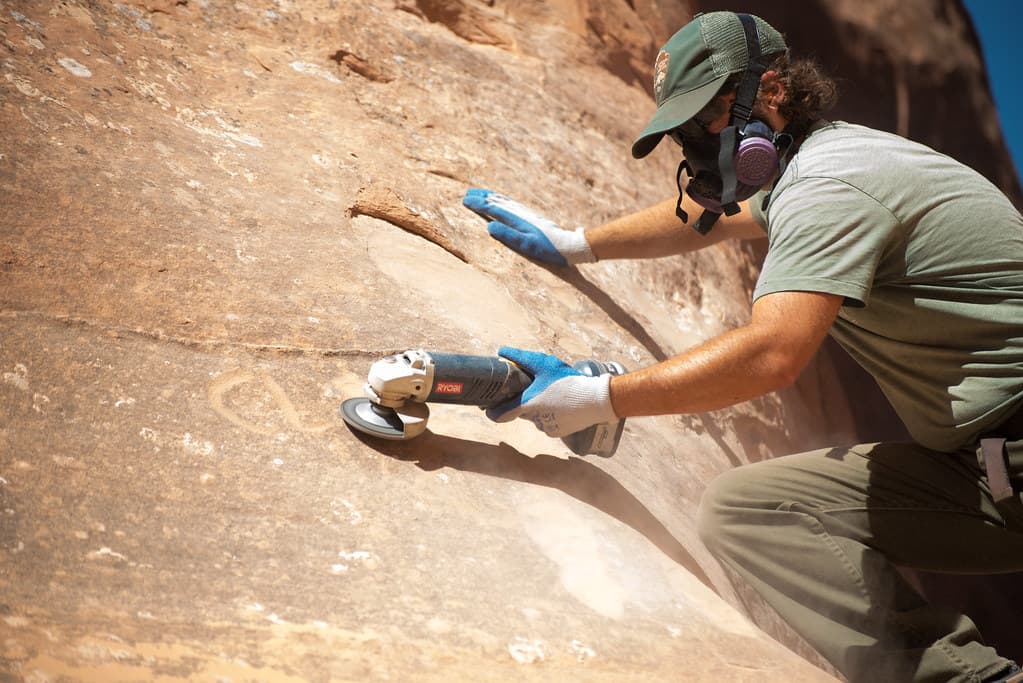 Park Maintenance Staff Use Grinders to Remove Graffiti
