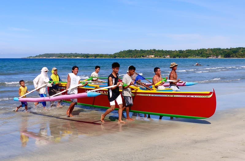 Fishermen Hauling ashore their boat.