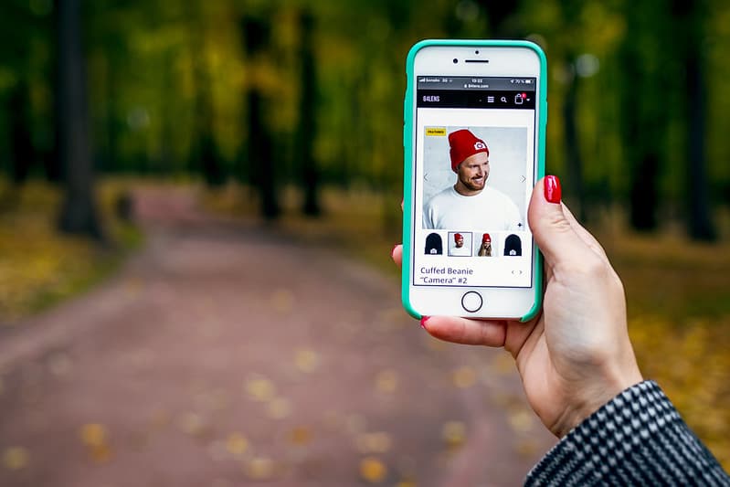 Woman hand with smartphone. Fall background.